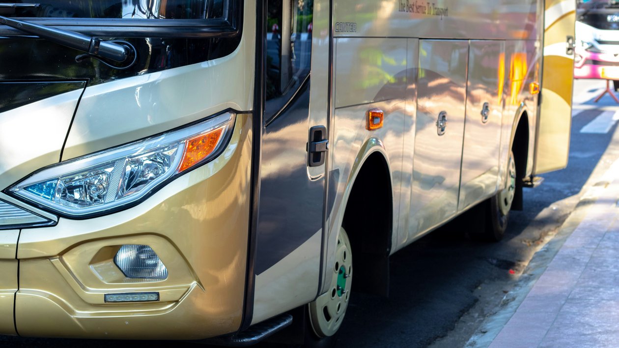 Bus im urbanen Umfeld Nahaufnahme eines Busses, der auf einer Stadtstraße geparkt ist, mit Fokus auf die Front- und Seitenansicht.